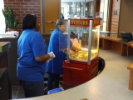 adults getting popcorn from machine