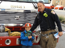 Boy with firefighter in front of fire truck