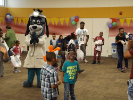 Children and family members playing with mascot