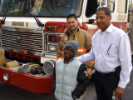Man, child and firefighter with truck