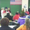 person presenting to a classroom with people at tables