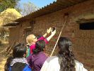 Team inspecting the window of a government-funded home that has been infilled with mud. 