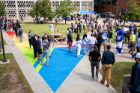 A crowd of people standing near the Progress Pride Paths Display in Knox Quad outside of the Student Union. Photographer: Meredith Forrest Kulwicki