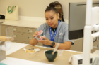 Program participant Carla Tahe makes a plaster model from an alginate impression that will be used to make a custom athletic mouth guard. Photo: Cass McAllister