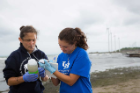 Suk holds a thermometer to measure water temperature.