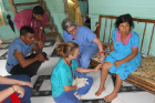 Family medicine resident Meghan Richli (with glasses) teaches Emily, a nurse practitioner who works on staff at Floating Doctors, how to do a steroid knee injection in an elderly woman with presumed arthritis. Emily lives in Bocas del Toro with her husband and two children.