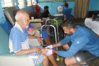 Medical student Aman Cheema applies coconut oil to the legs of a resident of the Asilo nursing home in Bocas del Toro.