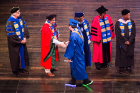 Teresa Miller (second from right) admires a graduate's eye-catching light-up sneakers while Andrew Stott, UB's vice provost and dean of undergraduate education, congratulates the student.