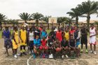 Participants in Ikenna Smart's basketball clinic in his home village in Nigeria show off their new sneakers.