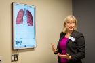 Renee Fillip, chief operating officer of UBMD Physicians’ Group, demonstrates to a tour group the digital instruction boards now available in UBMD patient rooms in Conventus. The boards allow physicians to explain conditions and procedures to patients using easy-to-understand visuals. 
