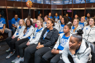 Members of the women's basketball team and coach Felisha Legette-Jack (center) watch the selection show in the locker room in Alumni Arena.