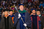 Philip L. Glick, chair of the Faculty Senate, carries the mace to lead off the academic procession.