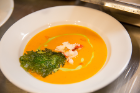 The Spicy Lobster Coconut Bisque is accented with crispy mustard greens and a cilantro drizzle.