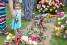 A family member takes a rose from the floral arrangement.