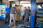 Tom Tiberi (far left), director of Campus Living, and UB Provost Charles Zukoski (far right) help students move in to Governors Complex. Photo: Meredith Forrest Kulwicki