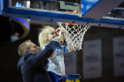 Coach Nate Oats helps his daughter cut down the net after the game.
