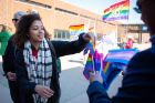 A parade-goer selects a rainbow flag.