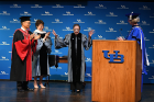 Ruth Bader Ginsburg acknowledges the applause from an enthusiastic crowd as she comes onto the stage to receive an honorary degree. With Justice Ginsburg are, from left, President Satish K. Tripathi; Merryl H. Tisch, acting chairman of the SUNY Board of Trustees; and Chancellor Kristina M. Johnson (at the podium). Photo: Nancy J. Parisi