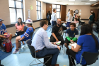 Second-year medical student Hillary Jaramillo (front right) and third-year student Timothy Felong (front left) speak with Darryl Means Sr. and his son, Darryl Means Jr., age 12.