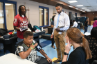 James Mack Jr., 9, a student at Maryvale Primary, has his blood pressure taken by second-year medical student Colleen Arnold. Standing by are Mack's father, James Mack (rear left) and second-year medical student Tarek Yamont.