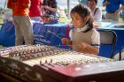 Eileen Li, 7, plays the Chinese dulcimer near the Confucius Institute table. Eileen is the daughter of Confucius Institute teacher Vicky Zou.