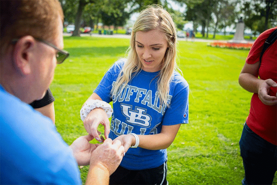 UB student Cassandra Rivier expresses surprise as a butterfly takes flight from her hand.