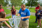 Nicholas Henshue (center), clinical assistant professor in the Department of Environment and Sustainability, holds a monarch butterfly captured by UB student Sadie Kratt (far left).