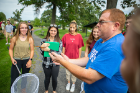 Nicholas Henshue (blue shirt), clinical assistant professor in the Department of Environment and Sustainability, releases a butterfly that has been tagged.