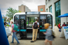 A student gets a look at "Olli," the autonomous shuttle bus.