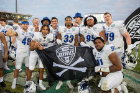 Bulls players pose with the special MAC Jolly Roger flag. Mid-American Conference Commissioner Jon Steinbrecher gave a flag to each conference institution playing in a bowl to fly after their victory. Photo: Meredith Forrest Kulwicki