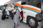 Sophomore linebacker James Patterson flashes the "horns up" as the team boards buses to the airport. Photo: Paul Hokanson