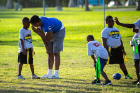 UB linebacker Rich Miller talks strategy with a young teammate at the youth football clinic held on Dec. 18 near the Thomas A. Robinson National Stadium, site of the Makers Wanted Bahamas Bowl. Youth ages 7-13 came out for drills, game play and end zone celebrations during the clinic. Photo: Meredith Forrest Kulwicki