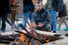 The fire is not just for cooking, as fifth-year student Jeremy Raymore warms his hands.