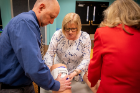 Beth Moses demonstrates how to pack a wound and apply pressure to stop the bleeding. PSS president Tim Tryjankowski (left) assists.