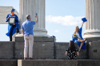 Rena O'Connor poses for photos as her dad, Tom (blue shirt), and sister, Lexi, serve as photographers. Rena graduated from the Jacobs School of Medicine and Biomedical Sciences. Photo: Meredith Forrest Kulwicki