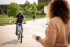 Dave Boody, who helped out with the bike days and works for the Ellicott Maintenance Team in Campus Living, rides Irene Mucci’s bike to test the chain repair.