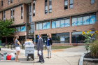 President Satish K. Tripathi and Christina Hernandez, interim vice president for student life (right) speak with a student (left) in front of Richmond 3 in the Ellicott Complex.
