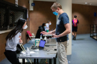 A student shows his ID at the check-in table.