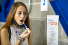 At the collection station, a student uses a swab to collect a saliva sample.
