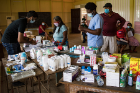 Medical workers prepare medications and other supplies in the pharmacy set up as part of the GSMSG medical clinic in the school. 