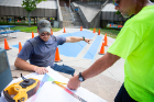 Workers consult the plans, which were designed by Sean Brodfuehrer, an architectural planner in Campus Planning. Brodfuehrer says he drew inspiration from the history and evolution of the Progress Pride Flag. 