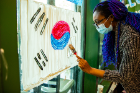 Adrianna Jarvis, a junior studying international trade and event coordinator for the Korean Student Association, paints a flag. 