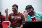 From left: Texas A&M graduate students Leonel Jimenez and Yu-Chuan Hsu each hold a crystal at eye level to get a closer look.