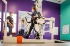 Fourth-year OT student Brooke Blazer (center) looks on as a client uses the Lokomat, a state-of-the-art robotic gait rehabilitation device designed to provide effective and individualized intensive training to increase the strength of muscles and the range of motion of joints to improve walking.