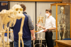 Assistant Professor Nicholas Holowka talks with student Ryan Gundrum during the class.
