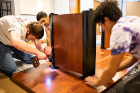 From left: Student volunteers Daniel Bauman, a sophomore studying law and criminology; Chaitanya Kuruganty; and Moaz Elazzazi, a sophomore mechanical engineering major, attach the legs to the table.