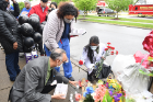 Placing flowers at the memorial site are (from left) Ranjit Singh (gray jacket), Sarah Abdelsayed (standing) and Sushama Thandja (white coat). Behind them holding balloons is Mesha Hines, an LPN at BestSelf.