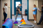 Maneuvering through an obstacle course of trampoline, tunnel and plastic “lava rocks” encourages balance and strength in motion. Crawling through the tunnel on all fours, for instance, works arm muscles and builds the ability to move in a stable way.