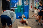 Students accelerate down a ramp on a scooter board and (safely) “crash” into a bolster-filled soft landing area. This sensory experience helps children move better through space and allows them to experience movement in a more sophisticated way.