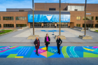 From left, Gender Institute Director Carrie Tirado Bramen, mural artist Cassandra Ott and Contemplative Sites Subcommittee chair Kelly Hayes McAlonie stand together on the new mural.